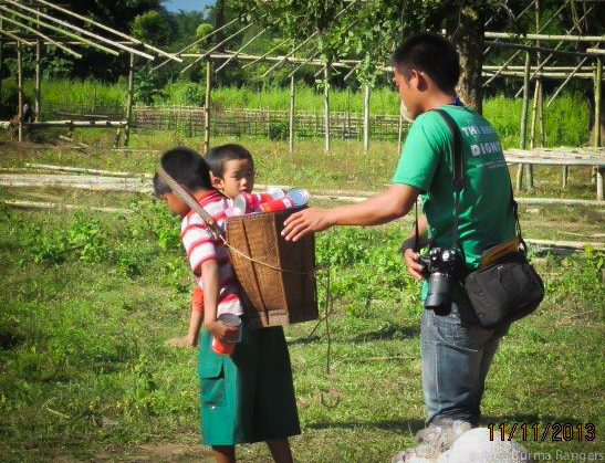 A Free Burma Ranger relief team member helps distribute food to Internally Displaced Persons (IDPs) in Nam Lim Pa, Kachin State.