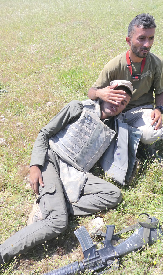 Shaheen helping a wounded Iraqi soldier right before he was shot.