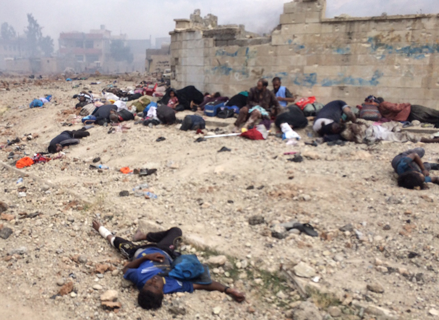 Those still living sit among the dead while waiting for help and surrounded by ISIS fire.