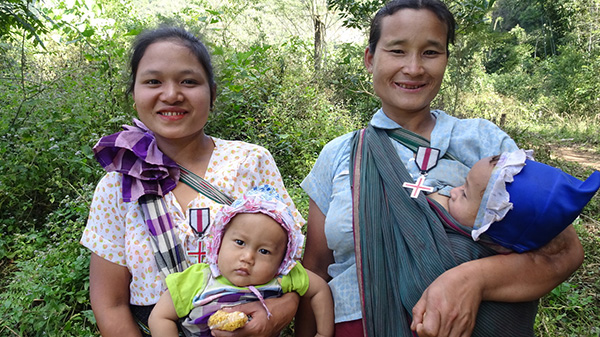 Naw Moo Day Wah and her baby, and Naw Ler Per and one of her children with medals we gave them, January 2018