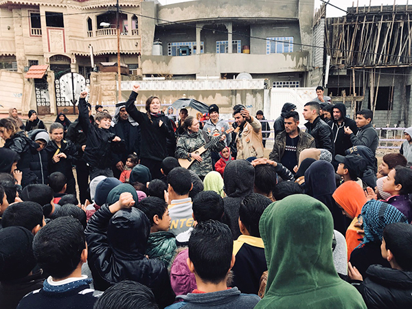 The team sings for families at a new playground in Mosul.
